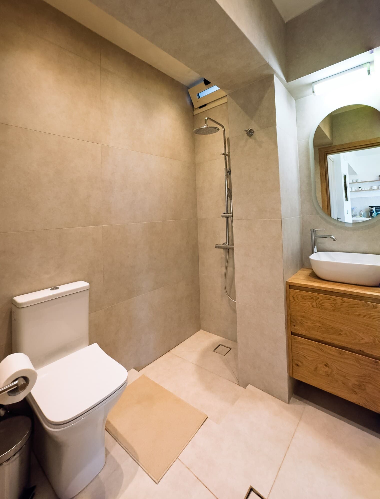 Bathroom with walk-in shower, mirror, and wooden vanity