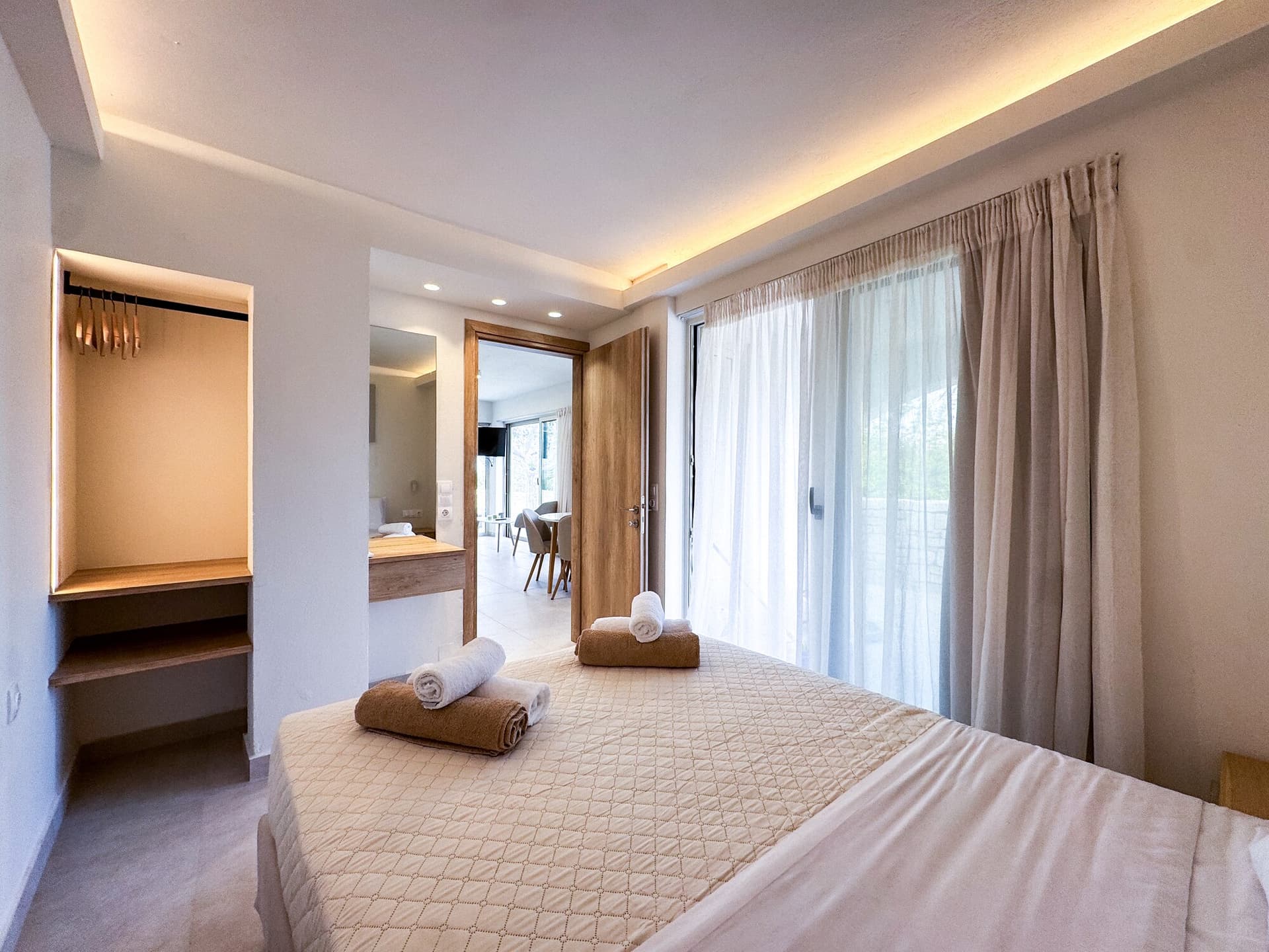 Queen bedroom at Nogal Retreat with towels and warm light