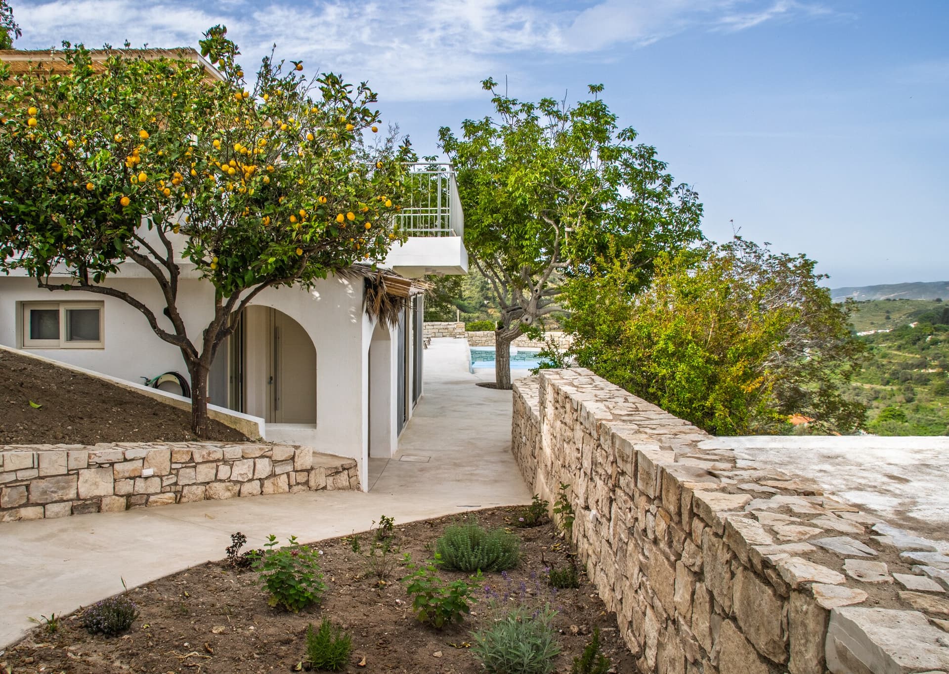 Stone approach and white walls on the way to the house