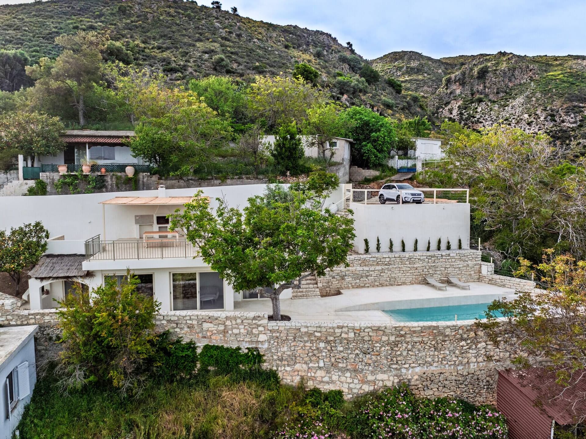Pool terrace and hillside view of the house at Nogal Retreat