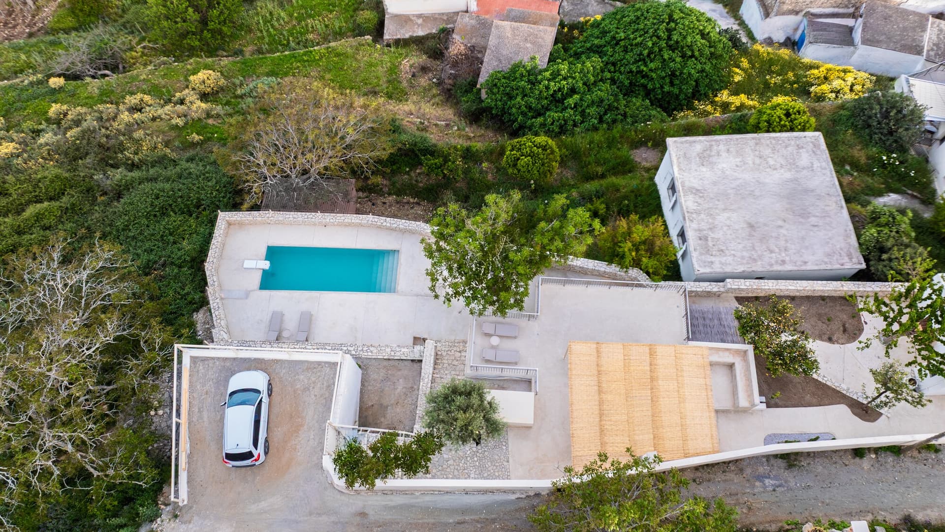 The villa, pool, and garden above the valley