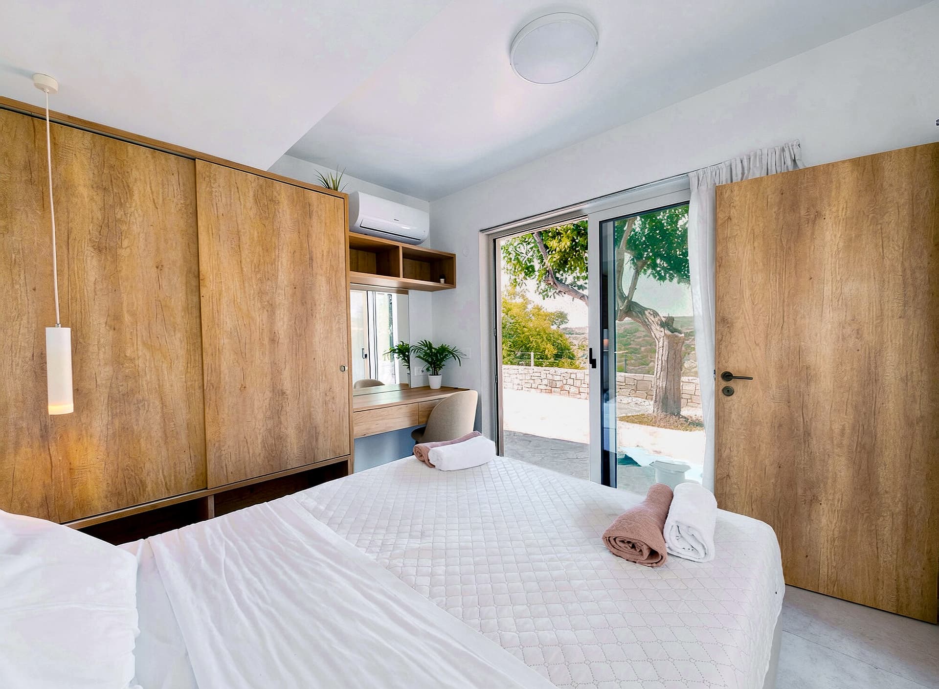 Full bedroom with wardrobe, desk, and balcony light