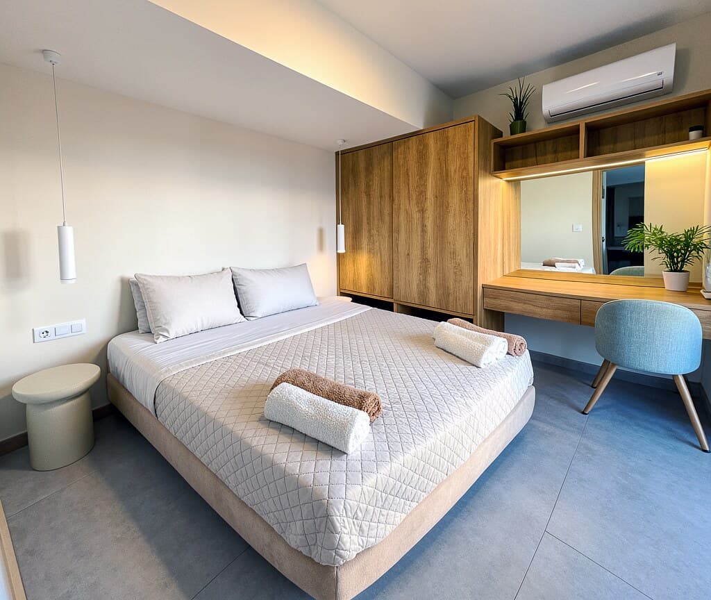 Bedroom with wardrobe, vanity desk, and soft blue chair